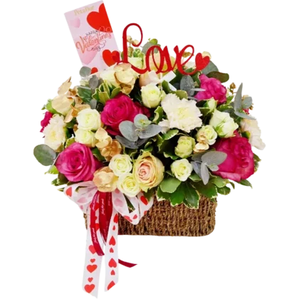 CM03: Canasta de mimbre rústica con rosas rosadas, claveles y topper decorativo de Love.