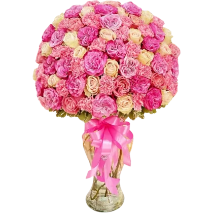 CR03: Florero de cristal alto con domo masivo de rosas rosadas y claveles en tonos pastel.